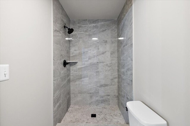 bathroom with toilet and tiled shower