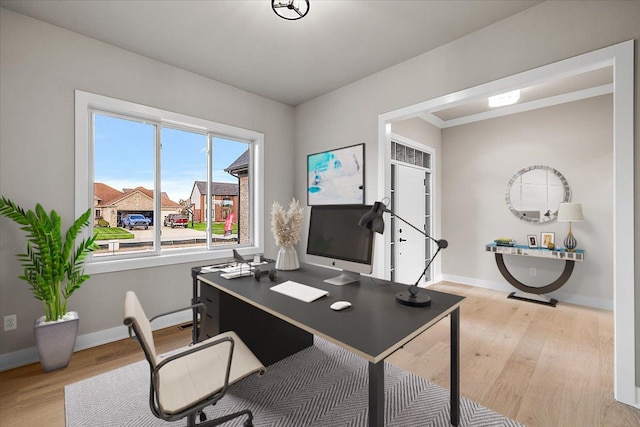 home office with light hardwood / wood-style floors