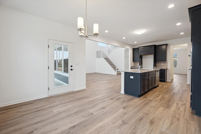 kitchen featuring a kitchen island with sink, plenty of natural light, pendant lighting, and light wood-type flooring