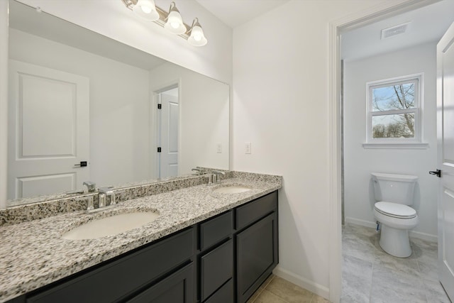 bathroom featuring tile patterned floors, vanity, and toilet