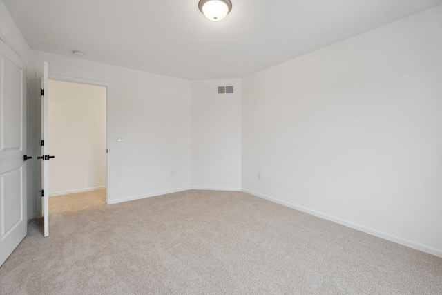 spare room featuring light colored carpet