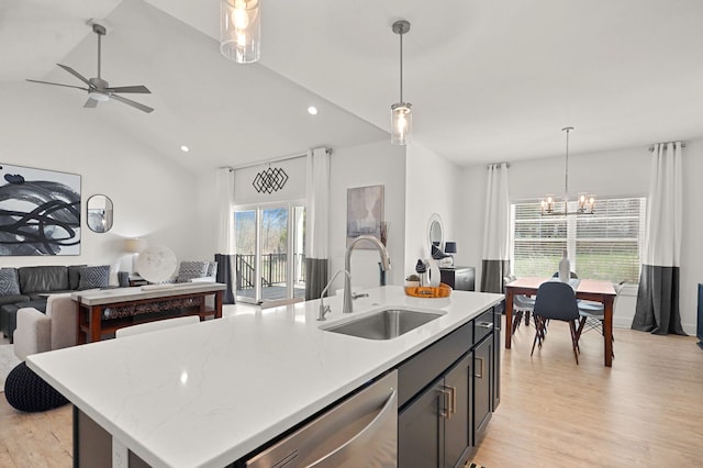 kitchen with a center island with sink, sink, vaulted ceiling, stainless steel dishwasher, and light hardwood / wood-style floors