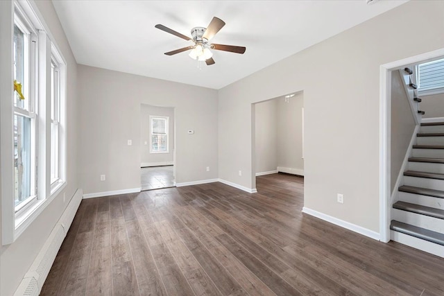 unfurnished living room with baseboard heating, ceiling fan, and dark hardwood / wood-style flooring