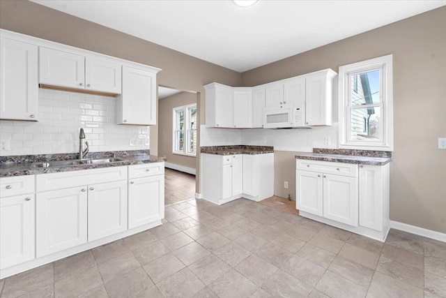 kitchen with white cabinets, backsplash, and sink