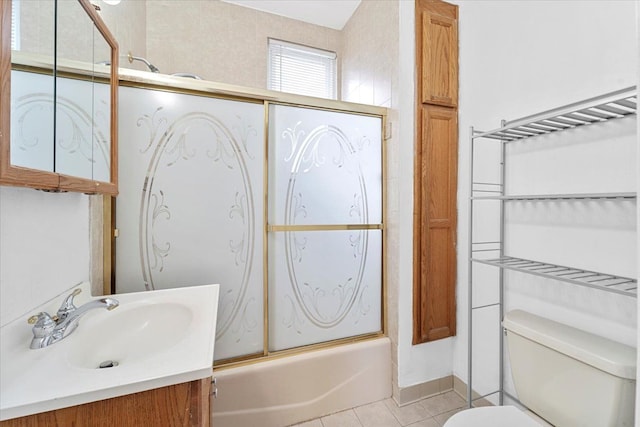 full bathroom with tile patterned floors, vanity, toilet, and bath / shower combo with glass door