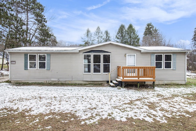 snow covered house featuring a wooden deck