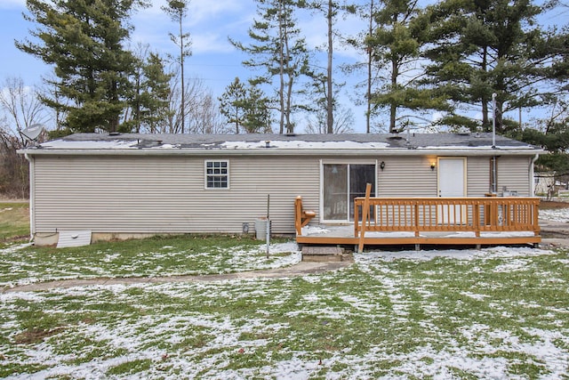 snow covered house with a yard and a wooden deck