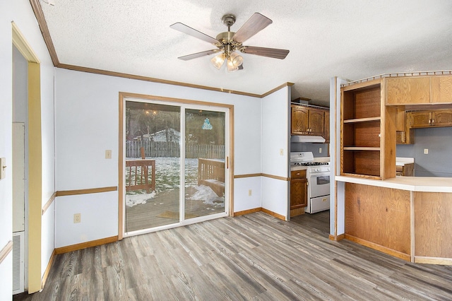 kitchen with crown molding, hardwood / wood-style floors, white range with gas stovetop, and a textured ceiling