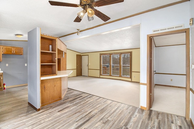 kitchen with a textured ceiling, light hardwood / wood-style flooring, vaulted ceiling, and ceiling fan