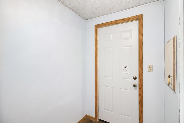 doorway to outside featuring a textured ceiling