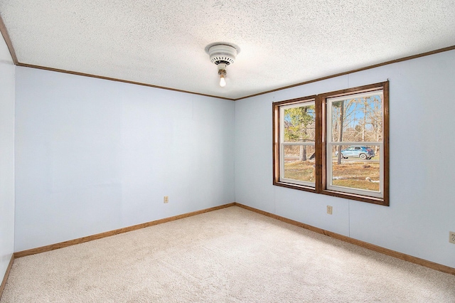 unfurnished room with carpet, ornamental molding, and a textured ceiling