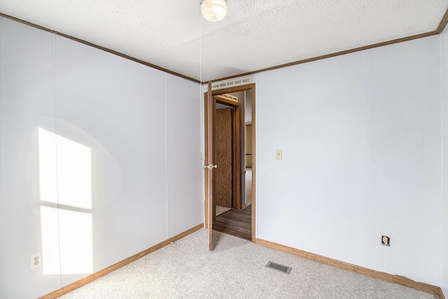 carpeted empty room with a textured ceiling