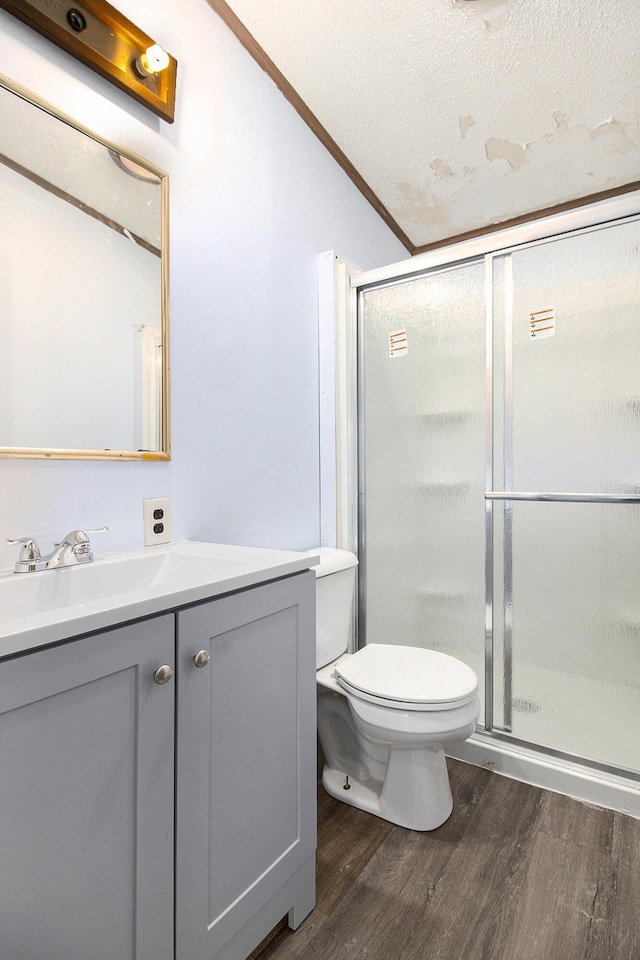 bathroom featuring hardwood / wood-style floors, vanity, toilet, ornamental molding, and a textured ceiling