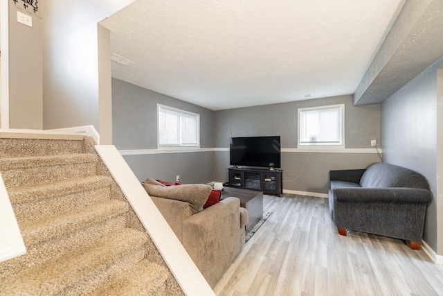 living room featuring hardwood / wood-style floors, a textured ceiling, and a healthy amount of sunlight