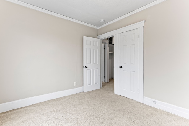 unfurnished bedroom with light carpet, a closet, and crown molding