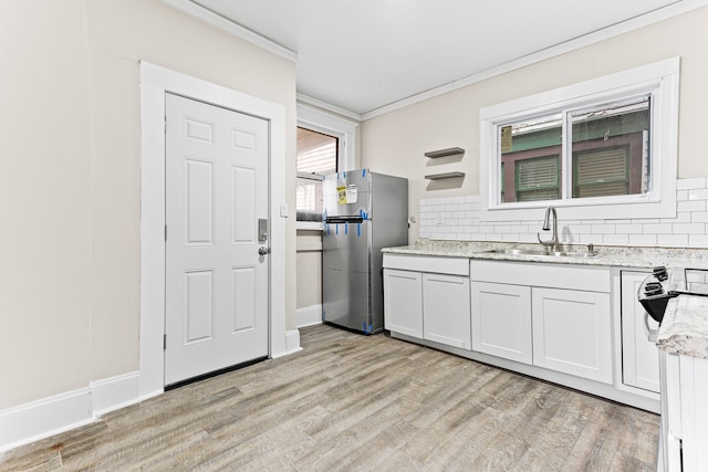 kitchen featuring light wood-type flooring, white cabinetry, crown molding, and sink