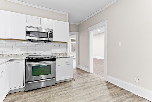 kitchen with white cabinets, appliances with stainless steel finishes, light hardwood / wood-style flooring, and light stone counters