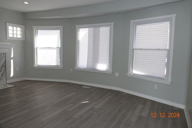 unfurnished living room featuring a fireplace and dark hardwood / wood-style flooring