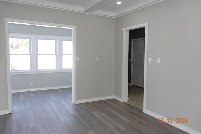 empty room with crown molding, beamed ceiling, and wood-type flooring