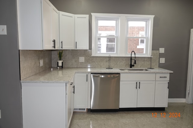 kitchen featuring light stone countertops, sink, white cabinets, and stainless steel dishwasher