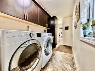 laundry room with washer and clothes dryer and cabinets