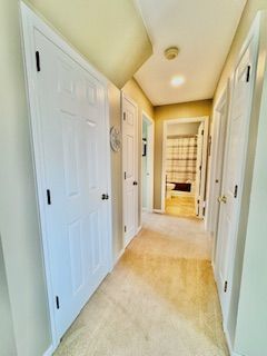 hall with light colored carpet