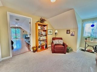 living area featuring carpet floors and lofted ceiling