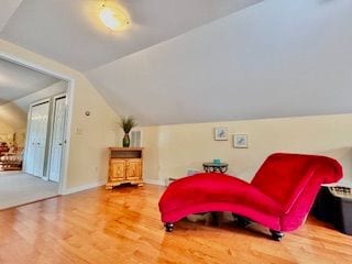 living area with hardwood / wood-style floors and vaulted ceiling