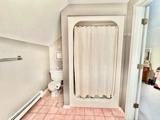 bathroom with baseboard heating, tile patterned floors, and a shower with shower curtain