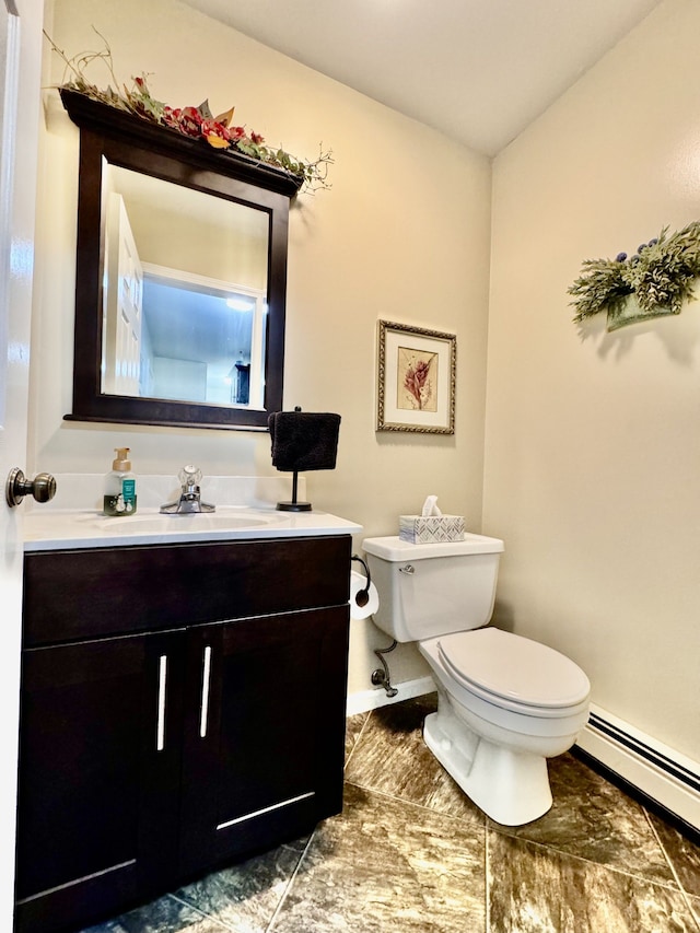 bathroom featuring baseboard heating, vanity, and toilet