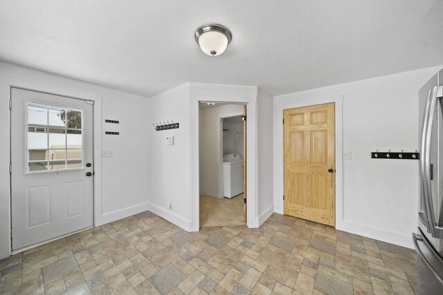 foyer featuring a textured ceiling and washer / clothes dryer