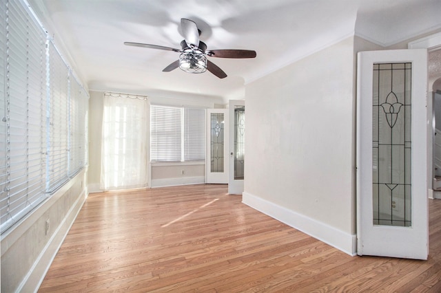 unfurnished room featuring ceiling fan, light wood-type flooring, and ornamental molding