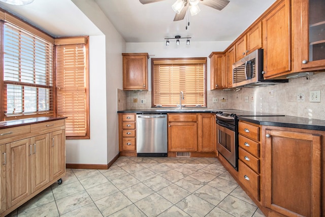 kitchen featuring ceiling fan, sink, backsplash, light tile patterned floors, and appliances with stainless steel finishes