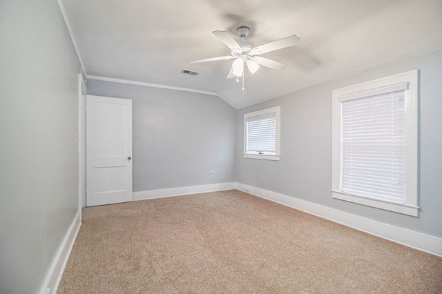 carpeted spare room featuring ornamental molding, ceiling fan, and lofted ceiling