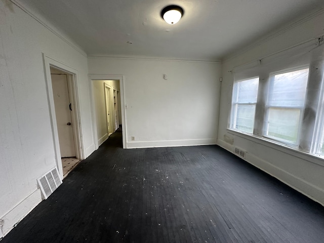 empty room with crown molding and dark wood-type flooring