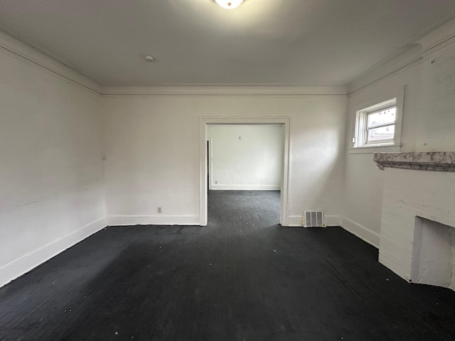 unfurnished room featuring a fireplace, crown molding, and dark wood-type flooring