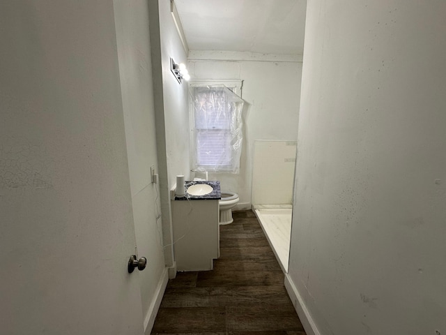 bathroom featuring hardwood / wood-style flooring, vanity, toilet, and walk in shower