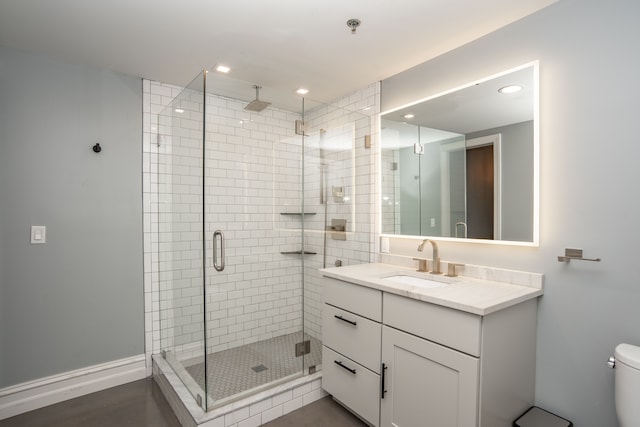 bathroom with vanity, toilet, and a shower with shower door