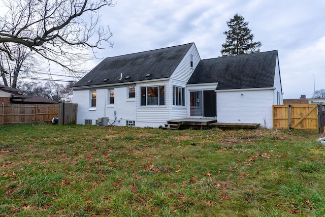 back of property with cooling unit and a yard