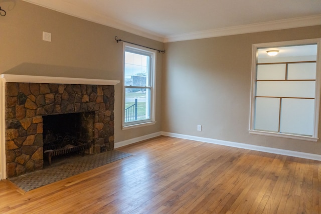 unfurnished living room with a fireplace, ornamental molding, and light hardwood / wood-style floors