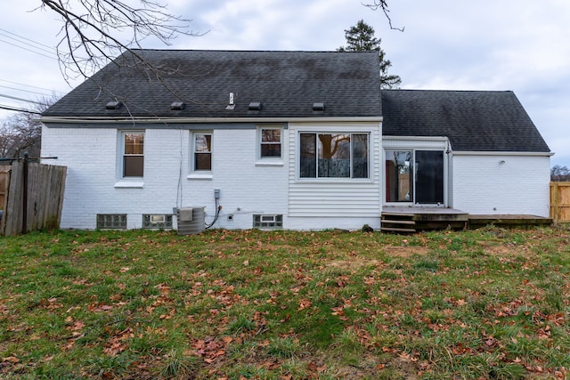 back of house with central AC unit and a yard