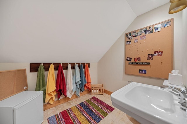 bathroom featuring sink and lofted ceiling