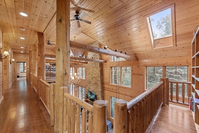 hall featuring a skylight, light hardwood / wood-style flooring, wooden walls, and wood ceiling