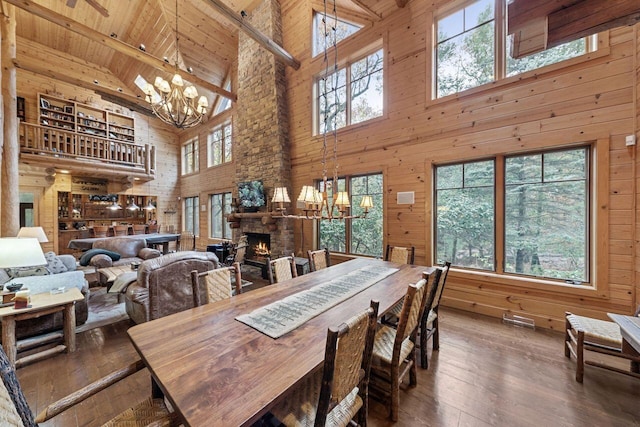 dining area featuring a fireplace, plenty of natural light, and high vaulted ceiling