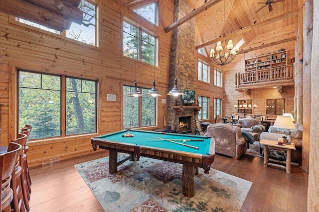 recreation room featuring wood-type flooring, high vaulted ceiling, wooden ceiling, beamed ceiling, and a fireplace