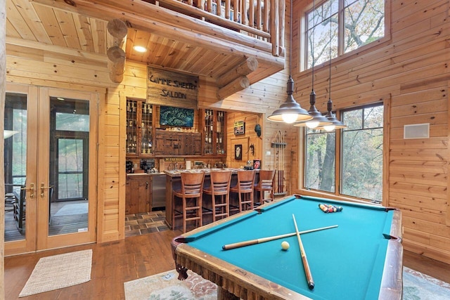 recreation room with indoor bar, wooden walls, and dark wood-type flooring