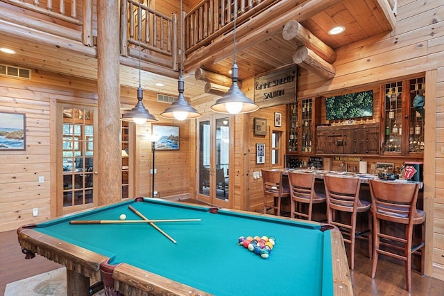 recreation room with wood walls, dark hardwood / wood-style flooring, a towering ceiling, and pool table