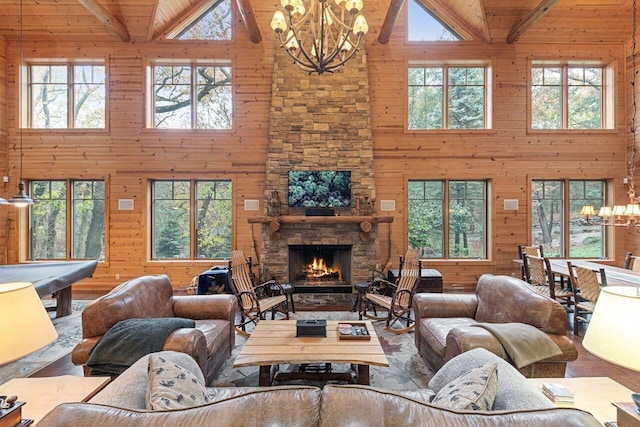 living room featuring beam ceiling, a stone fireplace, high vaulted ceiling, and wood ceiling