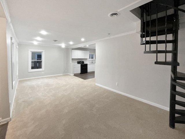 unfurnished living room with ornamental molding and carpet floors