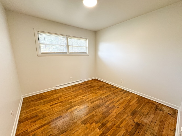 unfurnished room featuring a baseboard radiator and hardwood / wood-style flooring